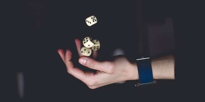 A hand throwing dice.