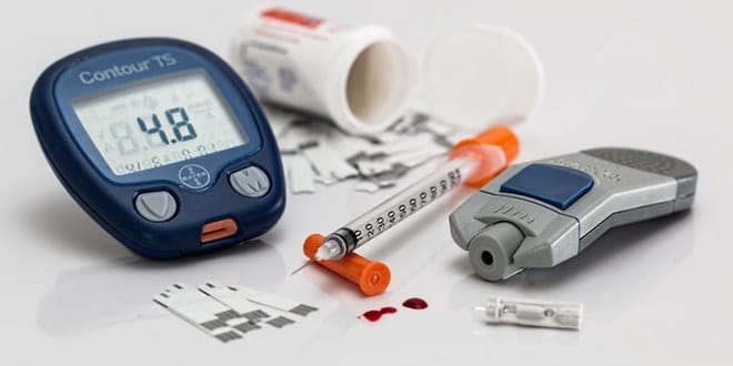 A group of medical equipment including a blood glucose meter and a syringe.