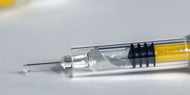 A syringe filled with a yellow liquid.