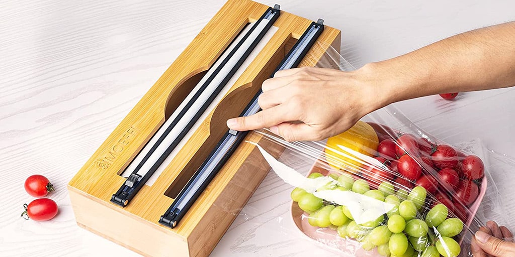 A person filling a box with fruits and vegetables.