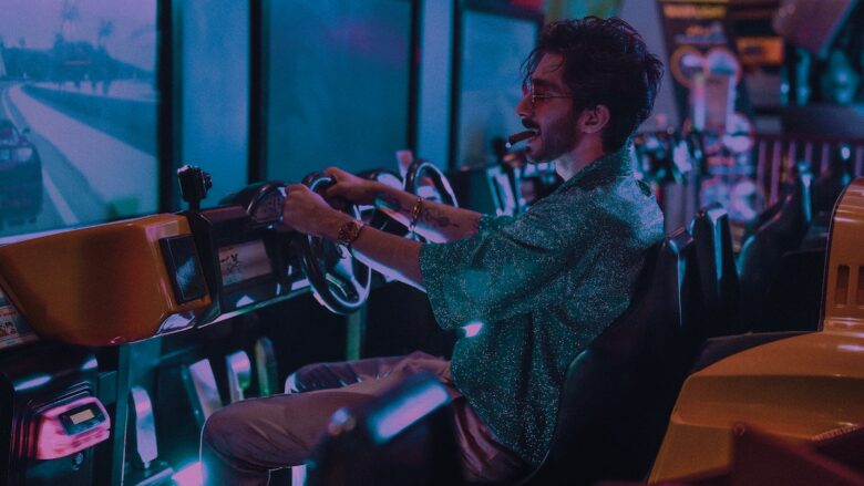 A cheerful man playing a video game in an arcade slot machine.