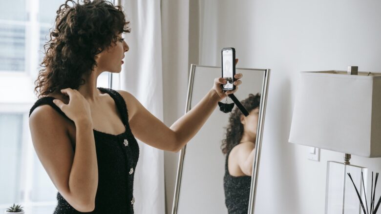 A woman taking a selfie in front of a mirror.