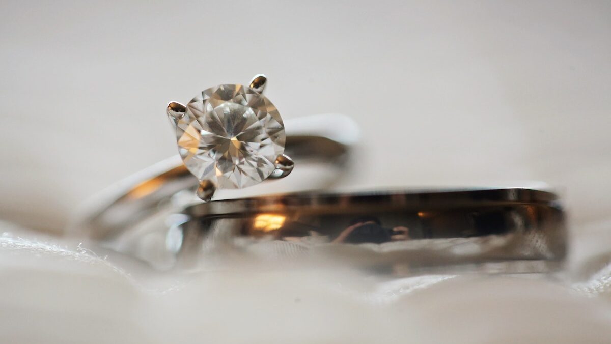 A silver-colored eternity wedding ring with a diamond sitting on top of it.