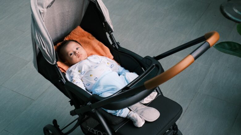 A baby is laying in a stroller.