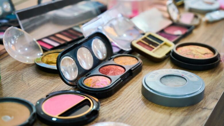 A variety of makeup products are arranged on a table.
