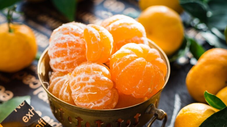 Fresh tangerines in a bowl on a table.