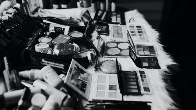 A black and white photo of a makeup table.